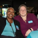 Replacements sponsor Sophia smiles with a Habitat Greensboro stakeholder at a 2023 Blueprints and Bubbly table