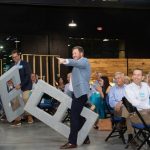 First Horizon's Chad and Eric hold large, Styrofoam concrete blocks at 2023's Blueprints and Bubbly