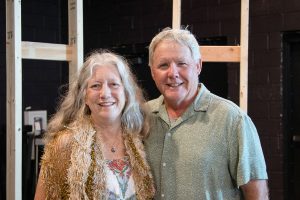 A man and woman stand shoulder-to-shoulder while smiling for the camera at Habitat Greensboro's Blueprints and Bubbly.