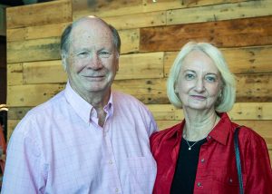 A man and woman stand shoulder-to-shoulder while smiling for the camera at Habitat Greensboro's Blueprints and Bubbly.