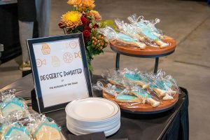 A tray of blue, champagne glass-shaped cookies sits next to a sign reading: "Desserts donated by the Muslims of the Triad"