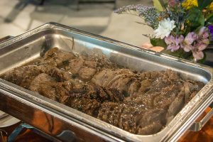 A silver, metal pan holds a beef-and-gravy dish