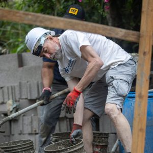 Man moving concrete for a foundation for a new house in Honduras.